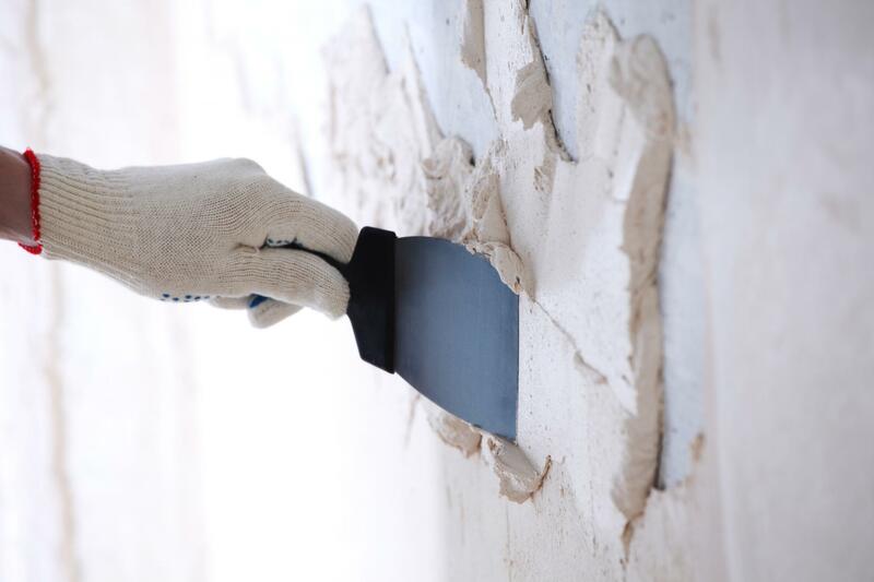 man putting plaster on wall