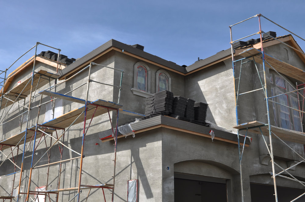 Worker putting stucco on wall
